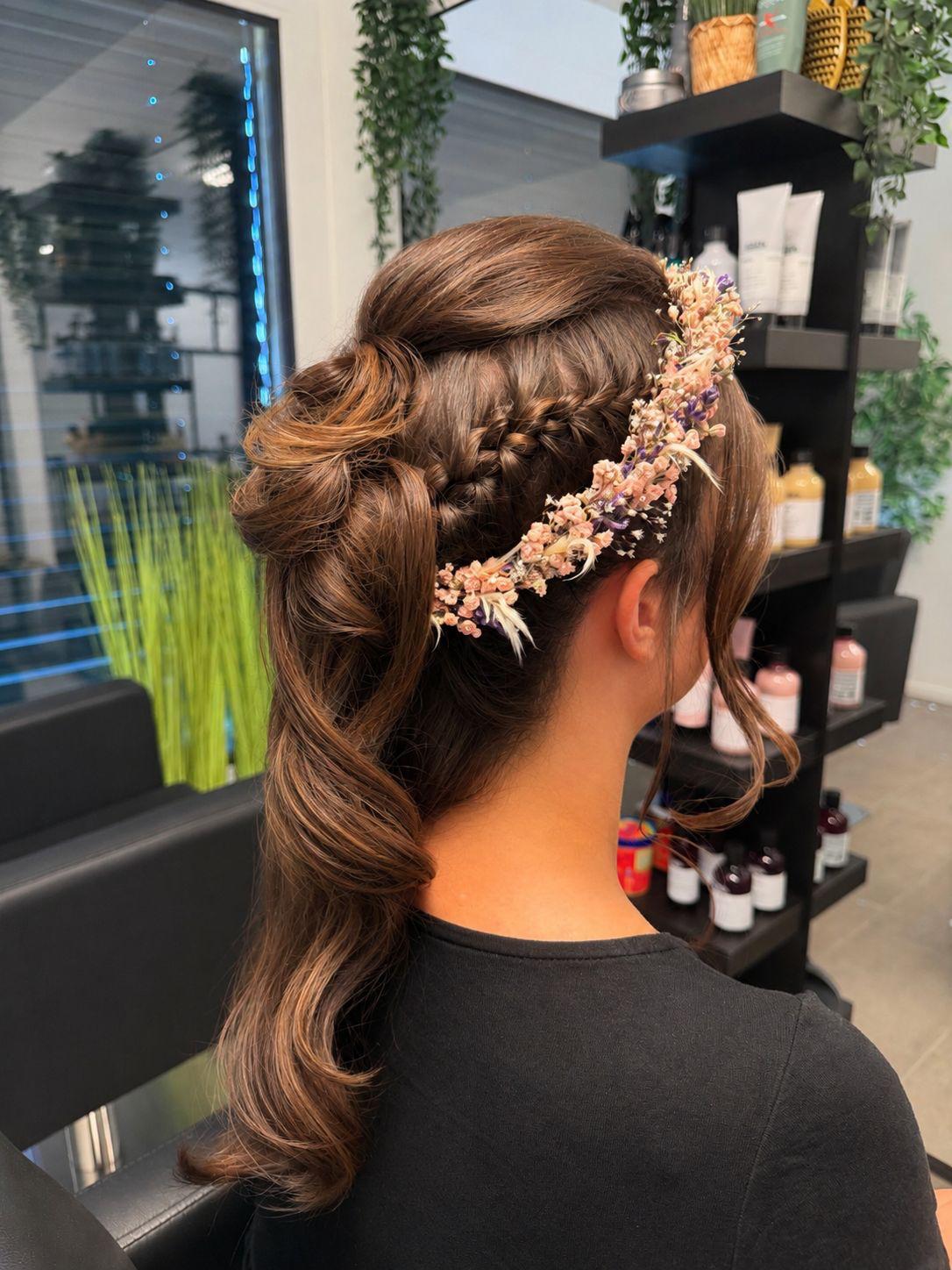 Brautfrisur mit Flechtdetail und Blumenkranz